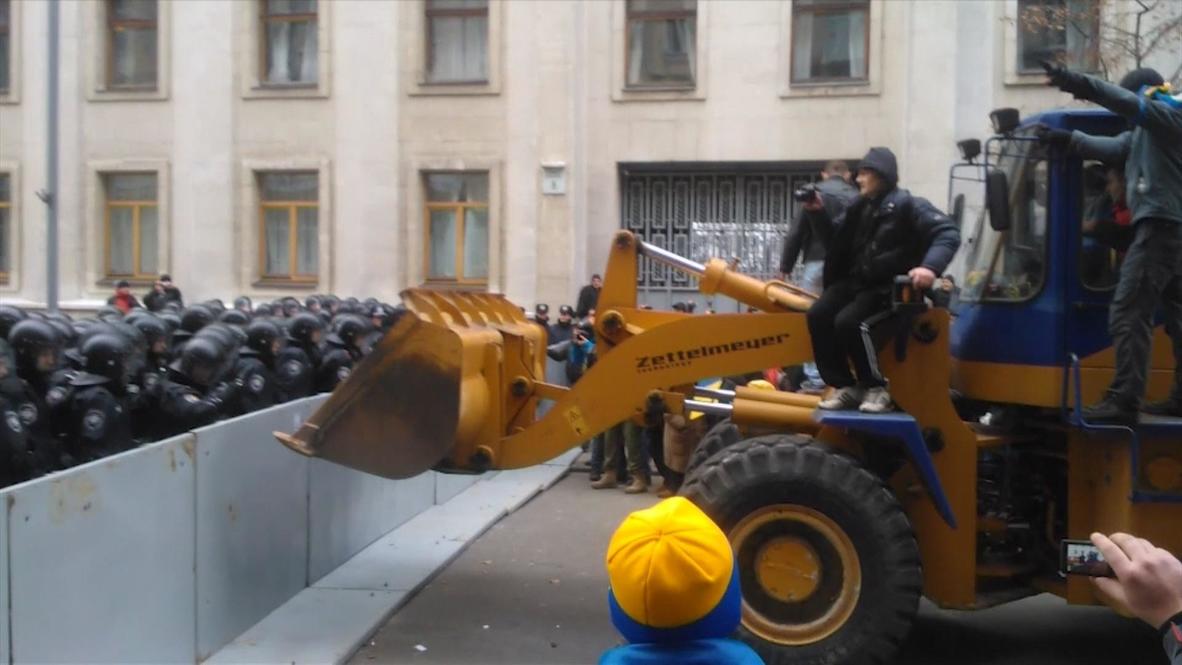 Ukraine: Protesters throw flares as a digger is driven through police barricade