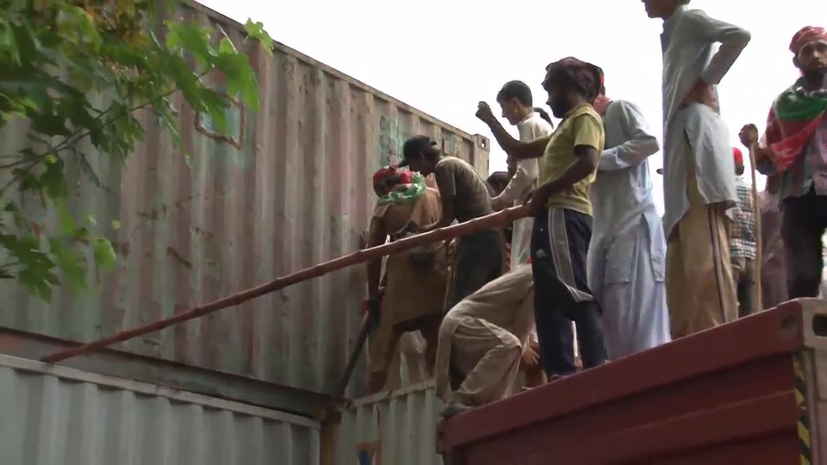 Pakistan: Watch protesters tear down barricade of shipping containers