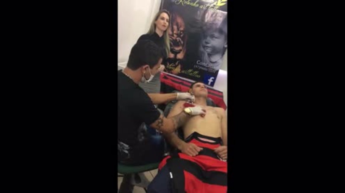 Brazil: Football crazy, football mad! Superfan TATTOOS team shirt to his torso