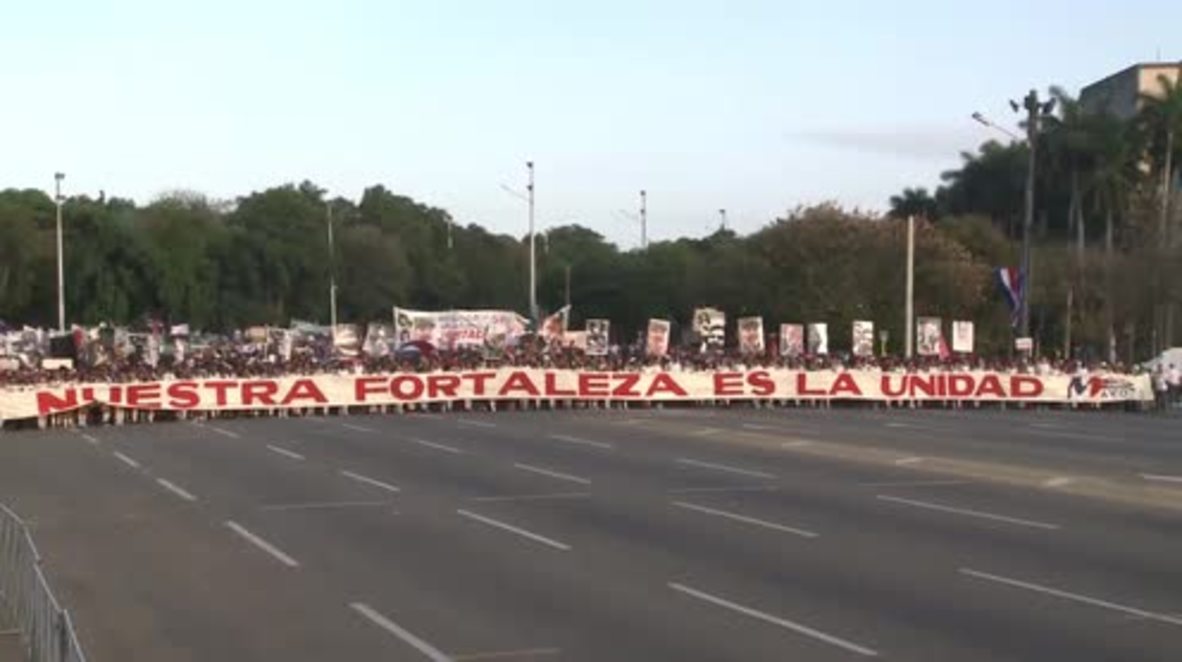 Cuba: Man with US FLAG sprints in front of May Day march in Havana