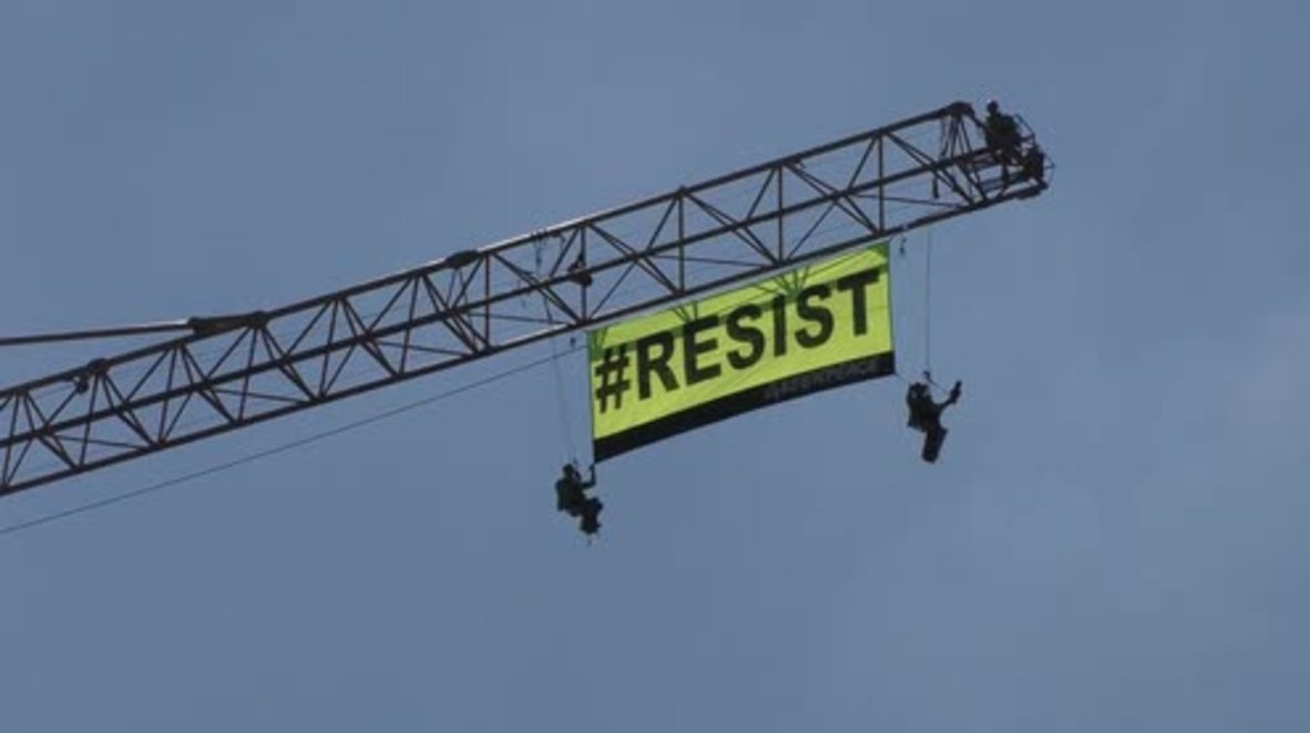 Belgium: Greenpeace activists scale crane near US embassy during Trump visit