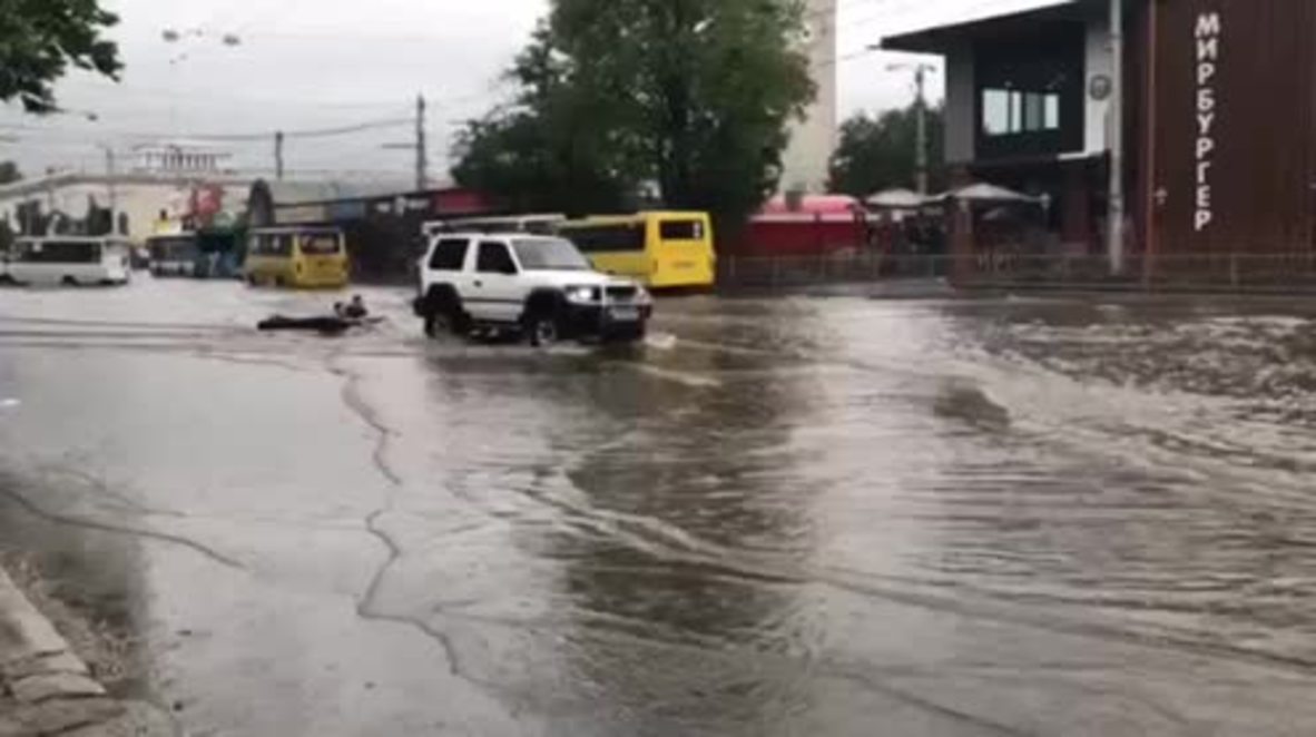 Russian kids surf through flooded streets behind 4x4