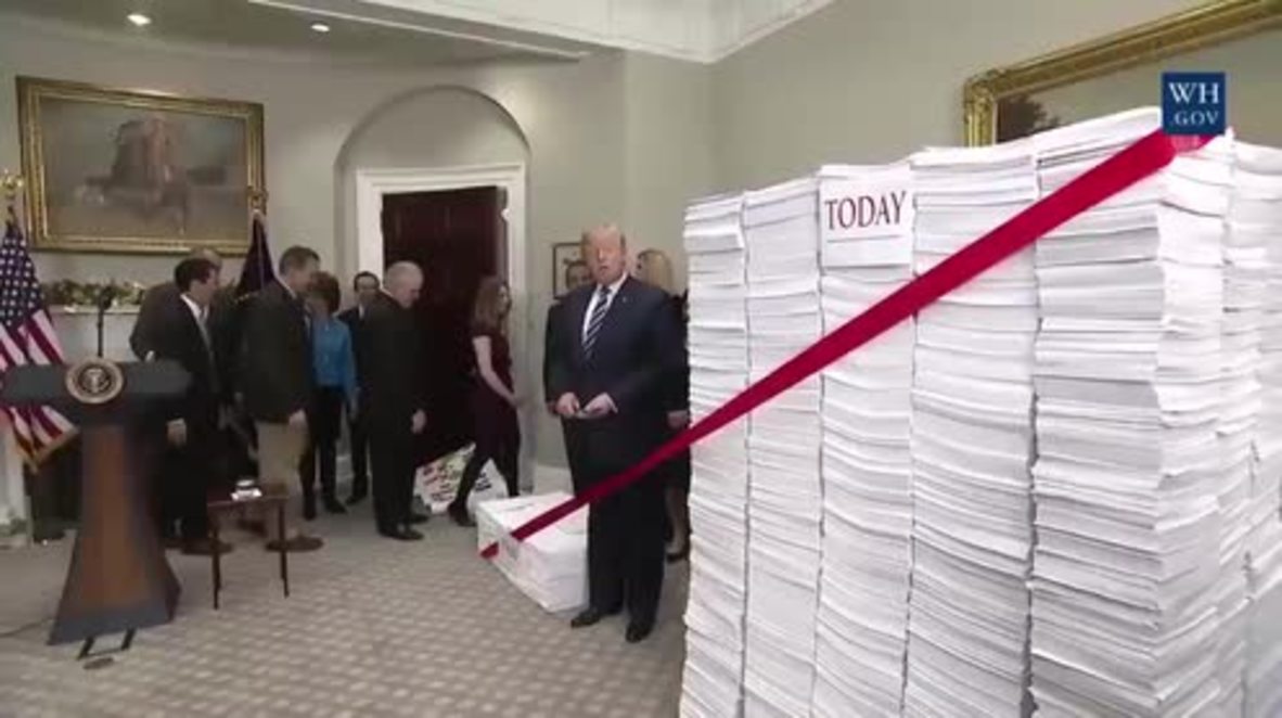 EE.UU.: Armado con unas tijeras doradas, Trump corta una simbólica cinta roja para "reducir la regulación