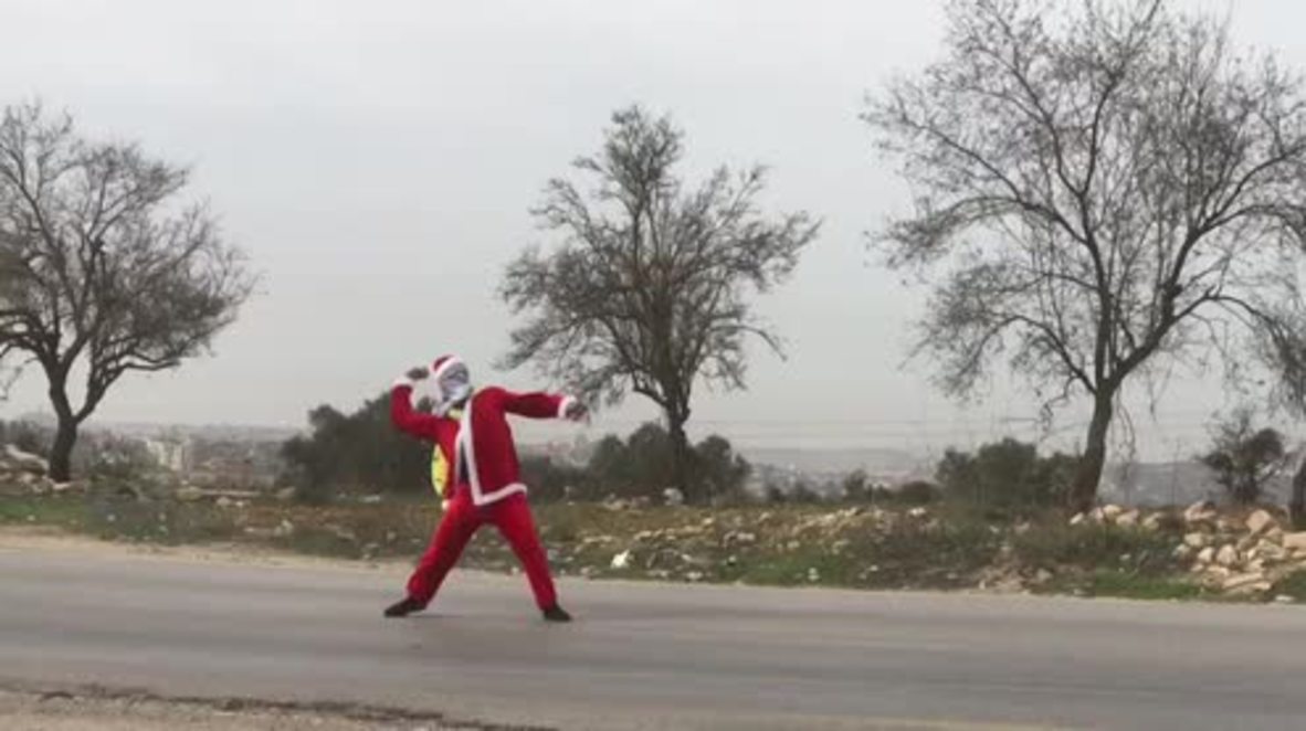 Estado de Palestina: ¡Jingle bell ROCK! Manifestante disfrazado de 'Santa' lanza proyectiles contra las fuerzas israelíes