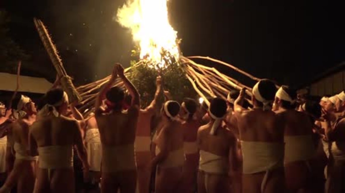 Loincloth-clad firestarters banish evil spirits with giant flaming torches