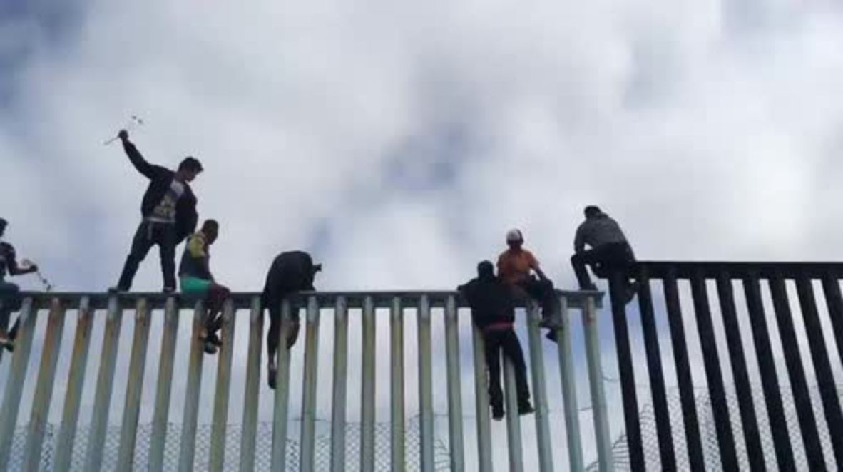Mexico: Caravan asylum-seekers climb Mexico-US border fence