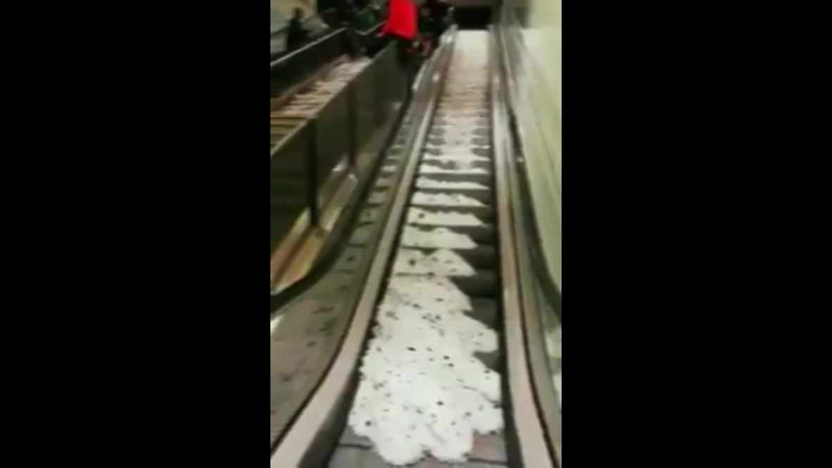 Hailstorm runoff floods underground escalators in Rome
