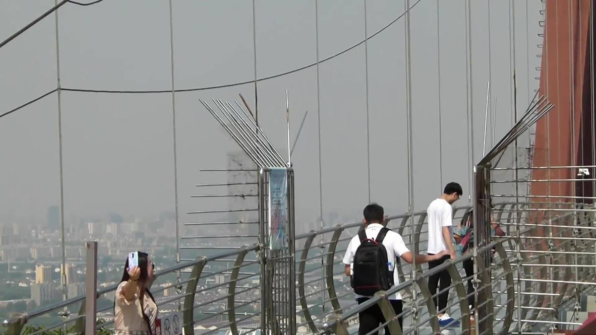 ¡No mires hacia abajo! Turistas se enfrentan al puente de vidrio más largo del mundo en China