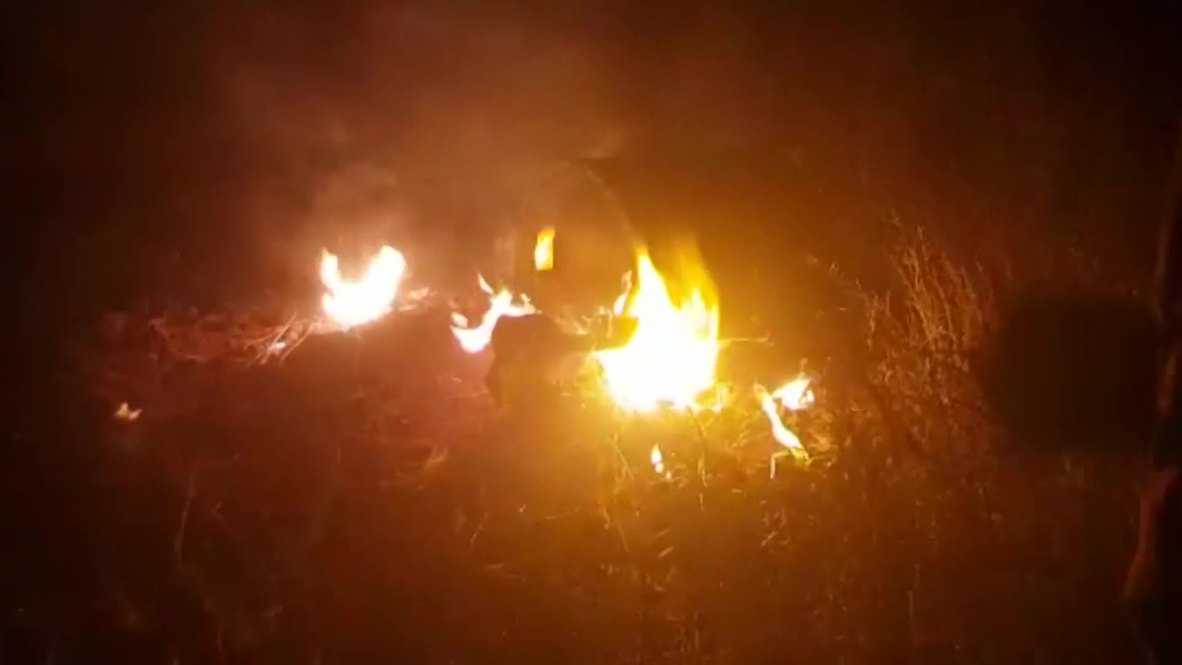 Syria: Burning debris litters field near aerial defence battery close to Kiswah