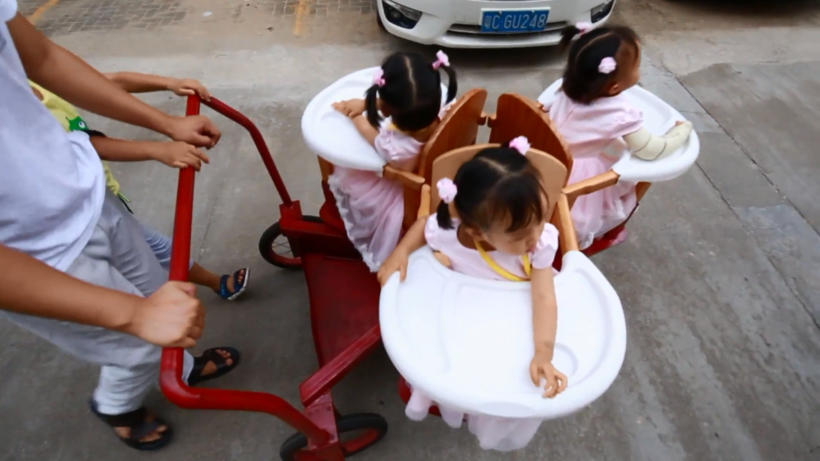 Este papá chino inventa un CARRITO GIRATORIO para sus hijas trillizas