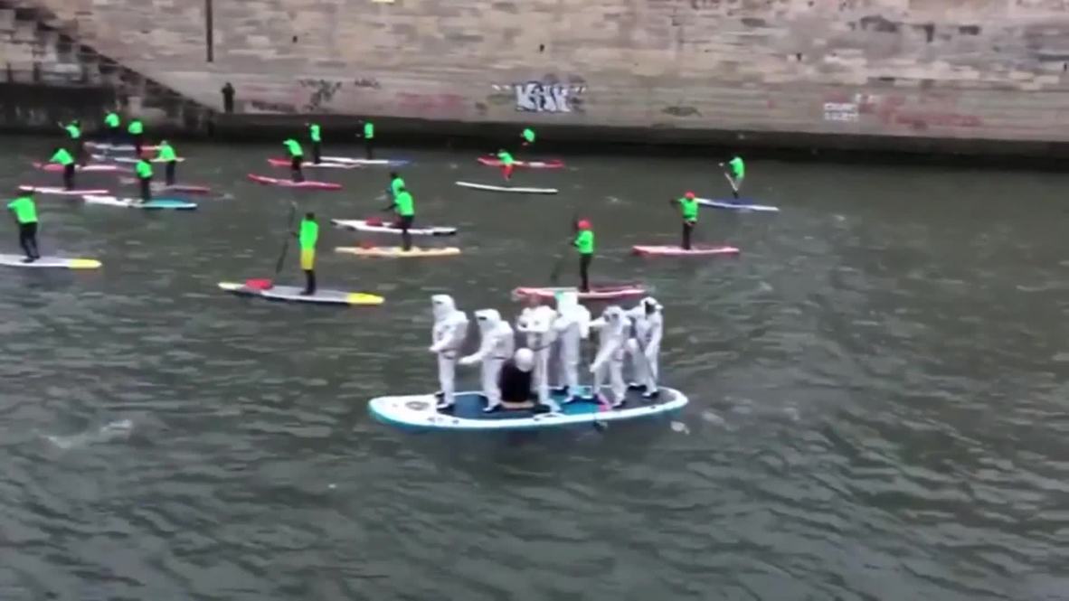 Cientos de aficionados del paddle surf participan en una carrera por el río Sena