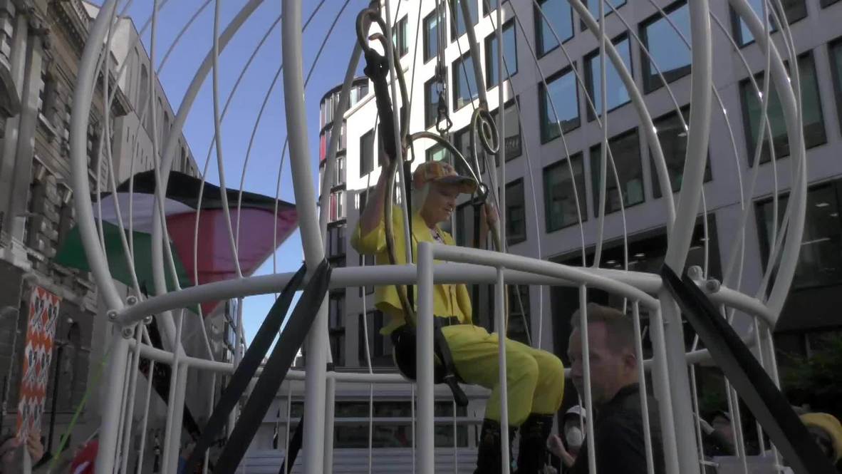 UK: Fashion designer Westwood suspends herself in bird cage in support of Julian Assange