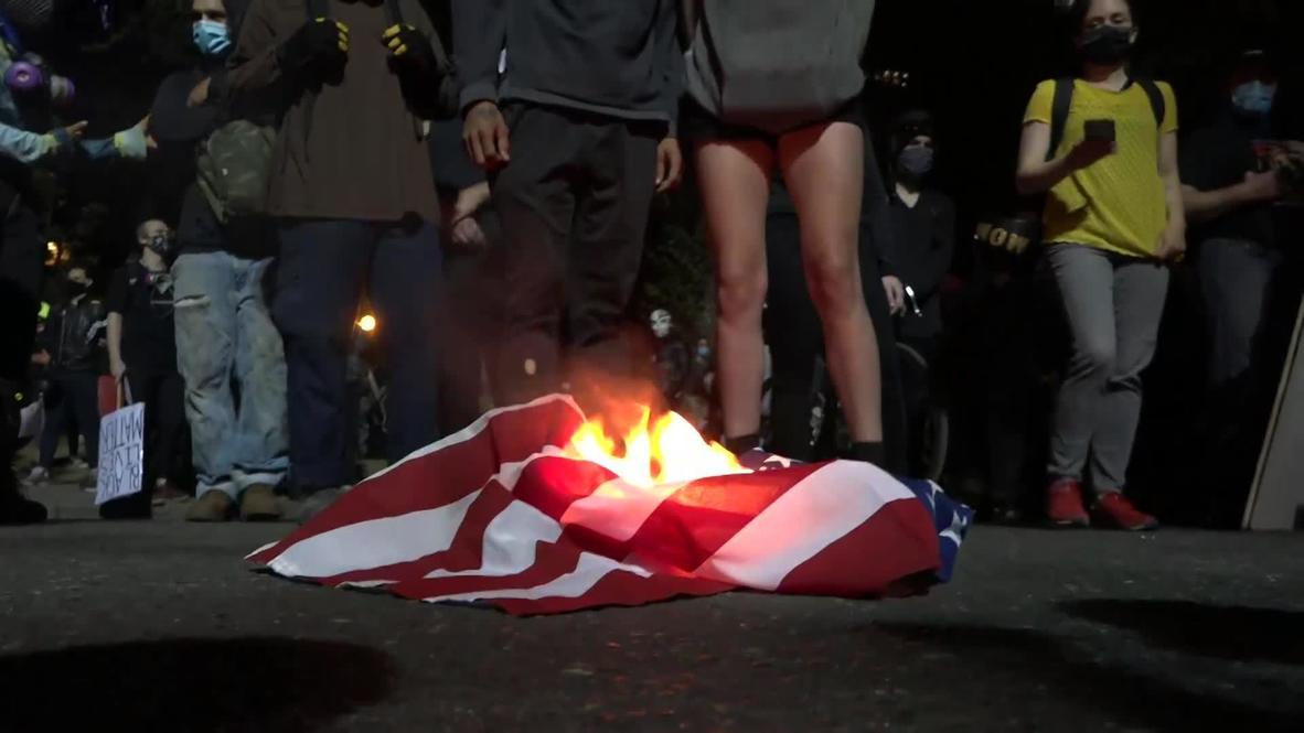 USA: Portland demonstrators set Bible and US flag alight on 65th night of protests