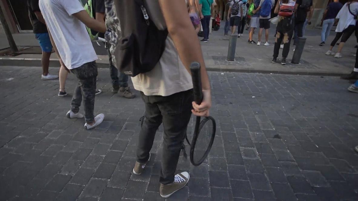 CORRECTION - Lebanon: Beirut protester uses tennis racket to launch stones during clashes with security forces