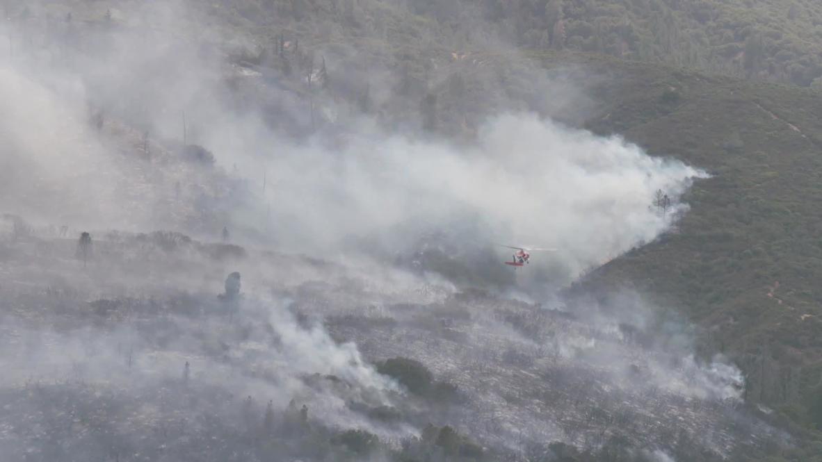 USA: Helicopter deployed to tackle wildfire over Lake Hughes in LA County