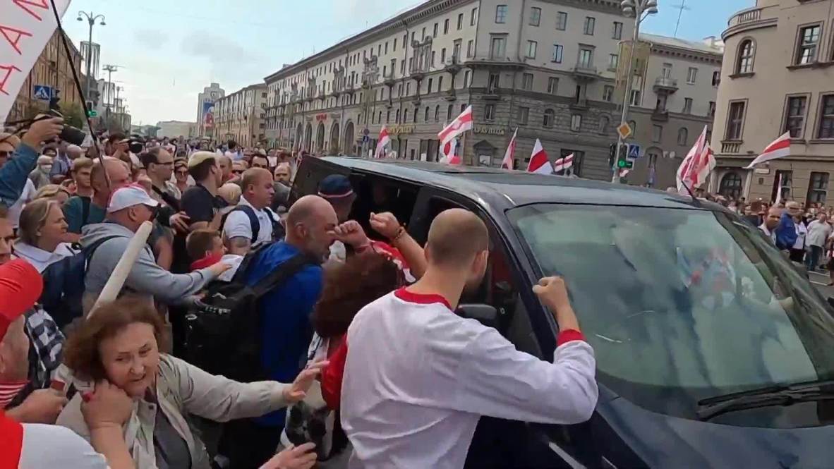 Белоруссия: Толпа митингующих набросилась на милицейский автомобиль в Минске
