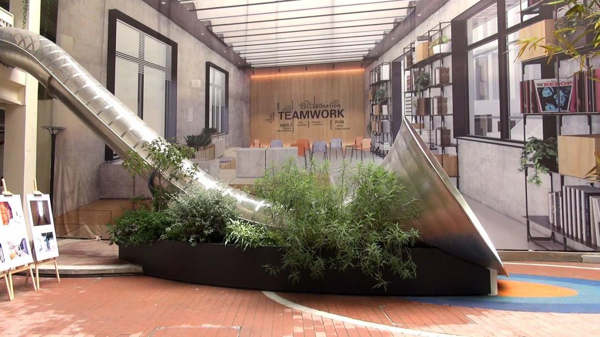 Work hard, play harder: Staff and visitors explore giant slide at Chengdu office block